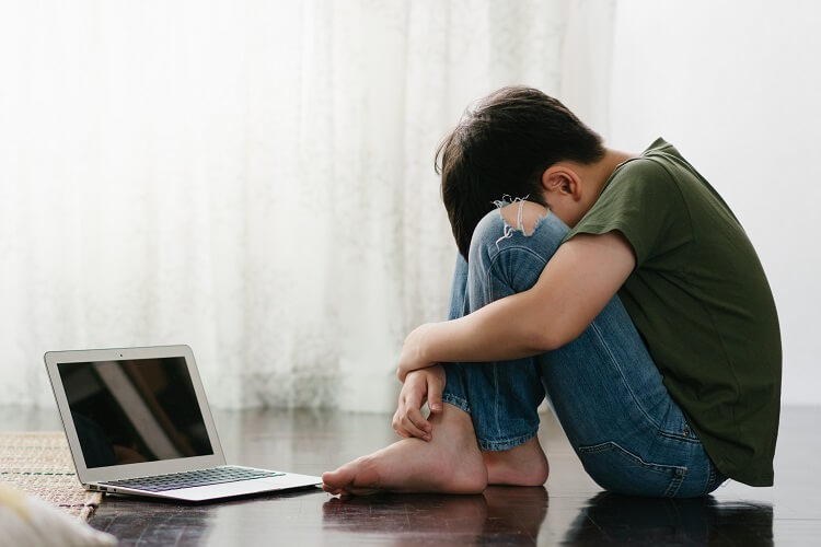 Criança chorando em frente do computador