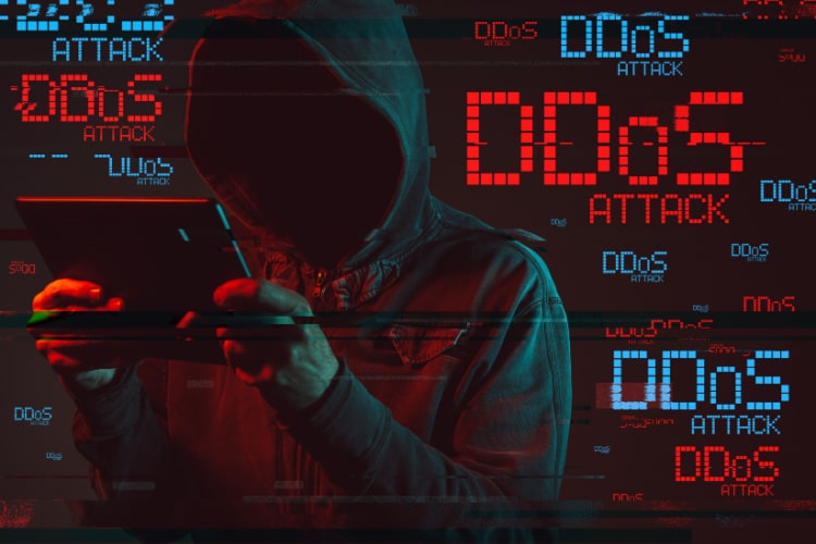 Hacker em foco com letras sobre ataques DDoS no Brasil.