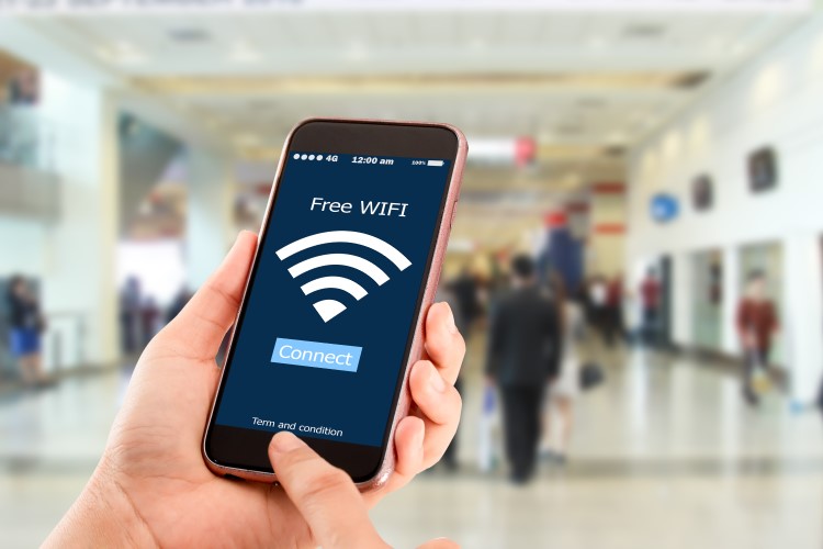 Pessoa conectando smartphone a uma Wi-Fi pública grátis.